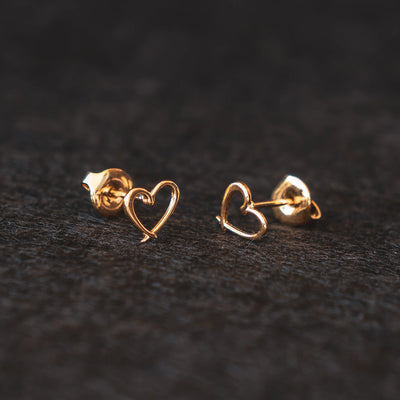 Orparima Boucles d'oreille modèle "Coeur" de la Collection Puces d'oreilles, sur fond noir. Bijoux dorés à l'or fin 24 Carats, complément idéal de votre tour d'oreille Orparima.