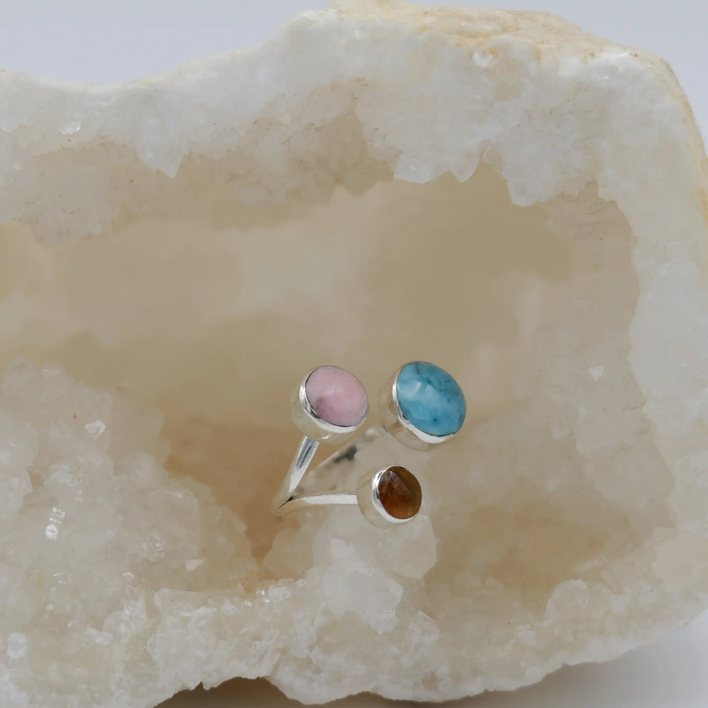 Bague dans une géode de quartz avec du Larimar, de l'ambre et du Lambi. Bijou artisanal fait en argent 925.
