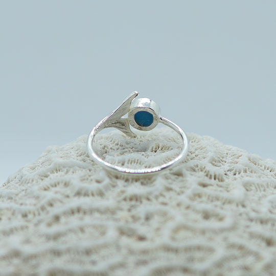 Bague posée sur un coquillage vue de derrière. Bijou en argent 925 fait à la main en République Dominicaine. Une pierre de larimar ronde est incrustée dans cette bague réglable