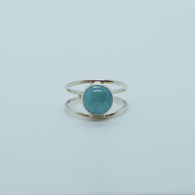 Bague en argent 925 avec une pierre de larimar ronde de couleur bleu. Structure de la bague en deux branches non fermés pour régler la bague à votre doigt.