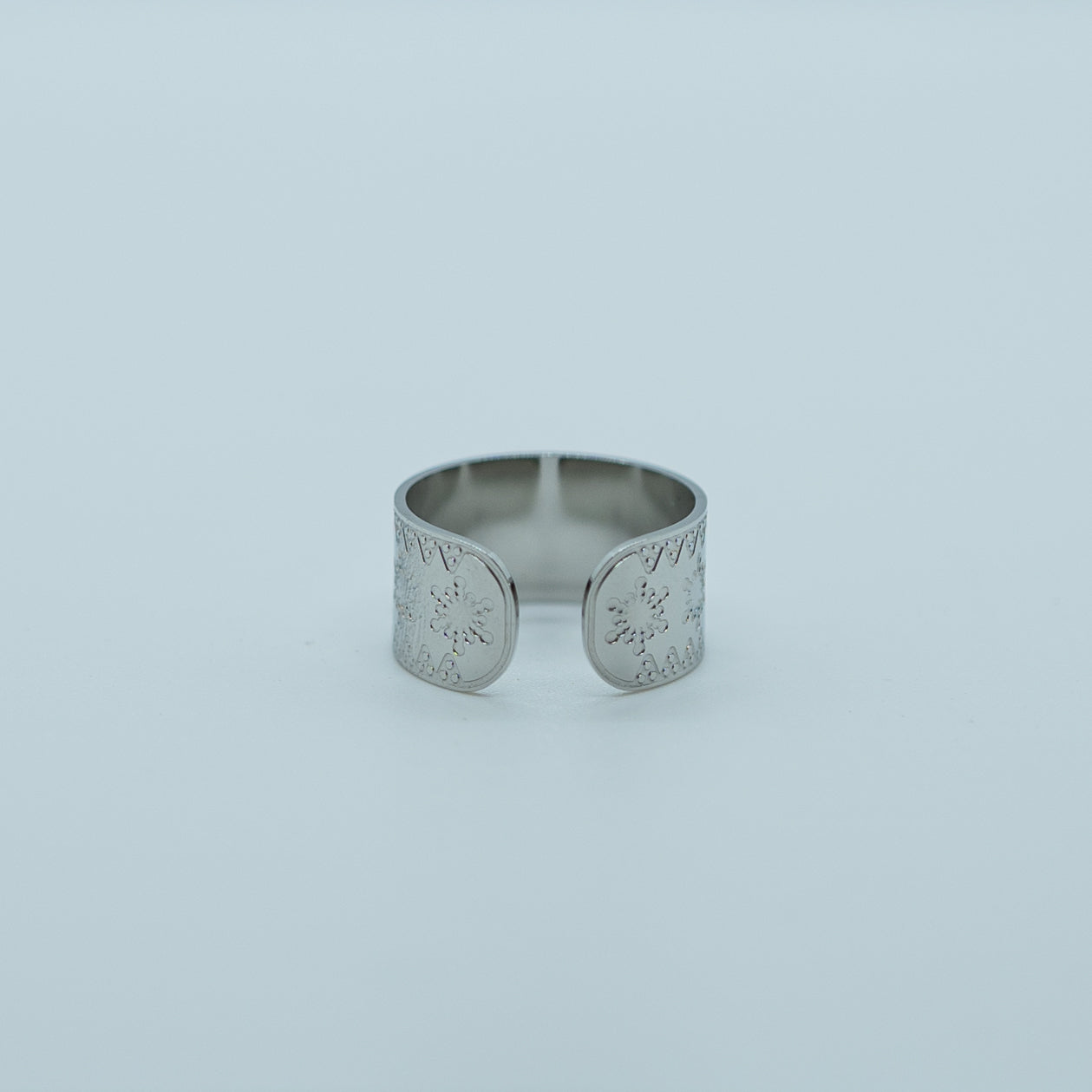 photo sur fond blanc d'une bague en acier inoxydable 316L argentée. Bague ouverte sur le bas et qui s'ajuste à la taille du doigt