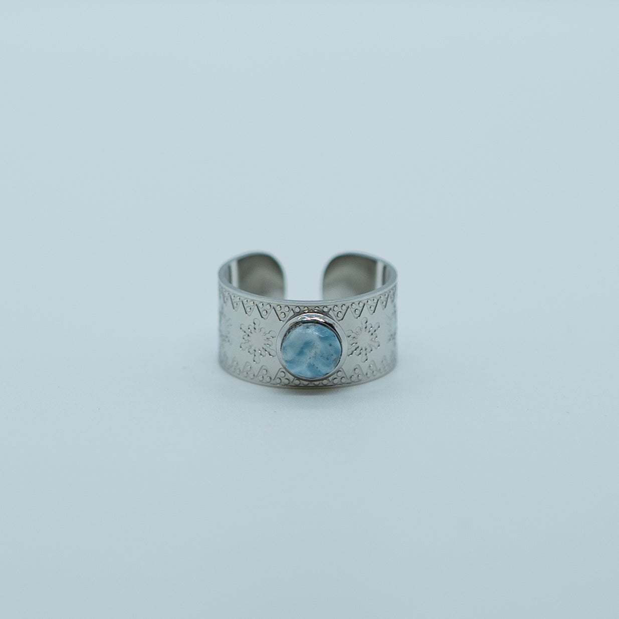 Bague de couleur argent, en acier inoxydable 316L, sur fond blanc. Pierre de larimar origine République Dominicaine sertie sur le dessus. Bijou tendance ajustable.