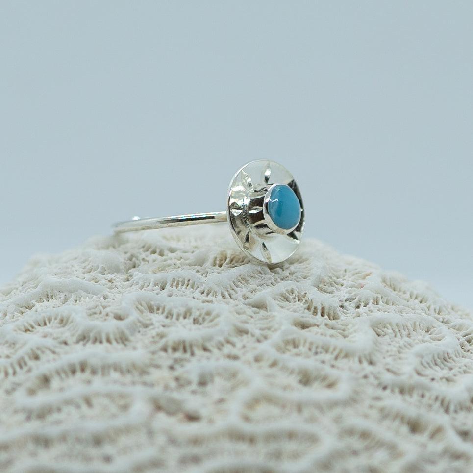 Magnifique bague en argent 925 avec un cabochon de larimar de forme ronde. La bague à une forme de soleil et est ouverte sur le dessous pour être réglable.