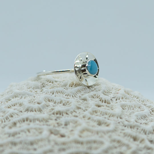 Magnifique bague en argent 925 avec un cabochon de larimar de forme ronde. La bague à une forme de soleil et est ouverte sur le dessous pour être réglable.