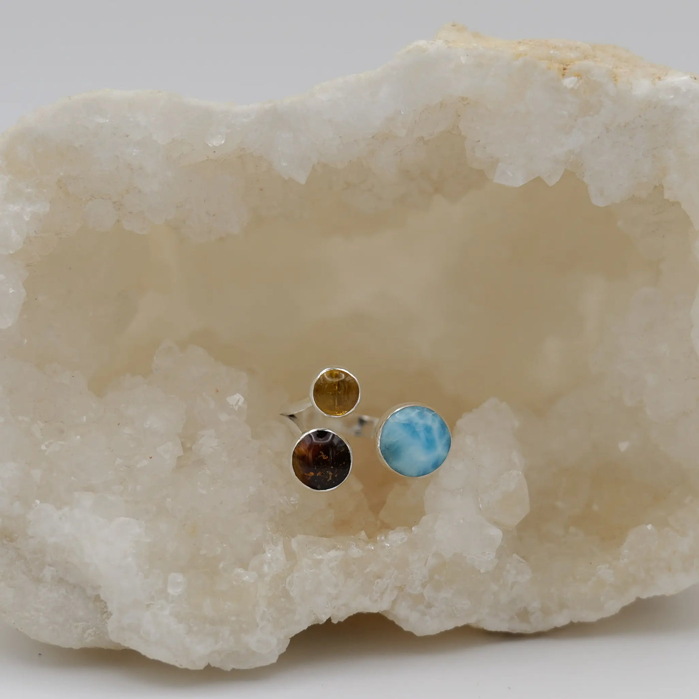 Bague avec 2 cabochons ronds en Ambre et un cabochon rond plus gros en Larimar de République Dominicaine. Bijou réglable.