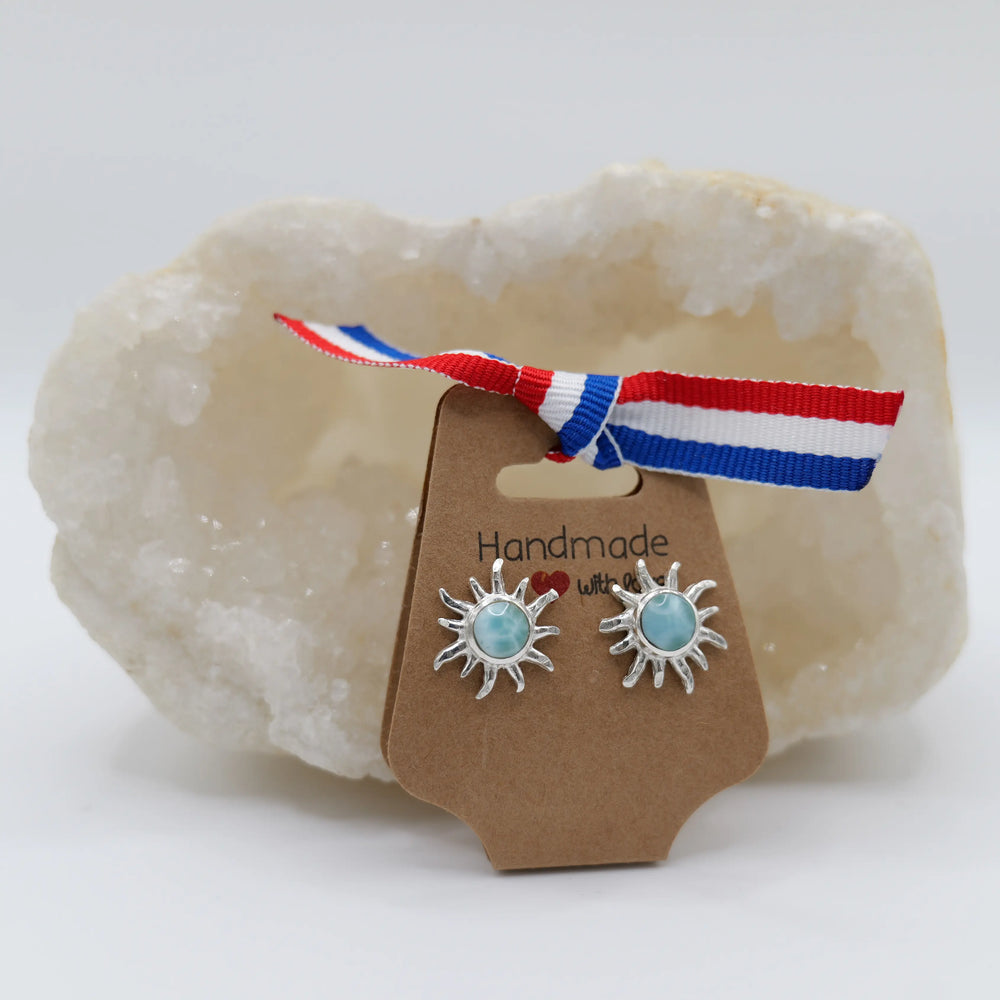 Magnifique pierre de Larimar de couleur bleue de forme ronde, montée au centre d'une paire de boucles d'oreilles en argent 925 en forme de soleil.