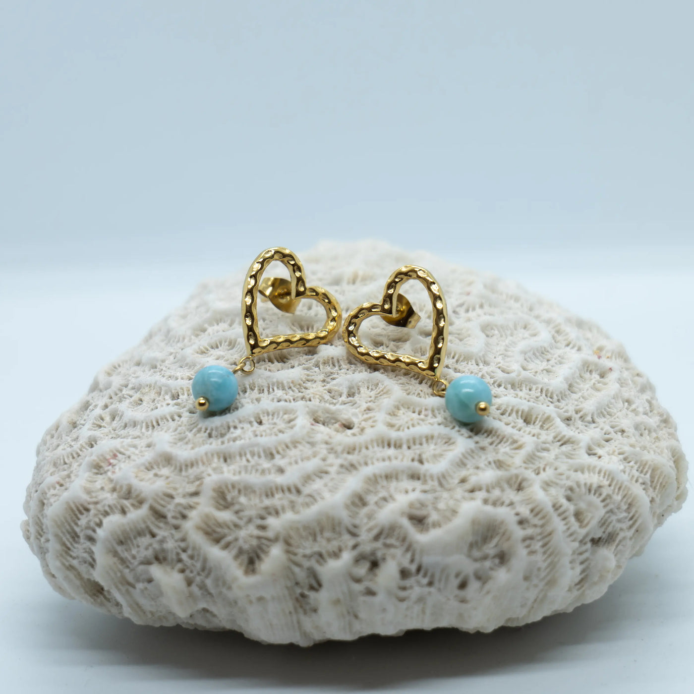 Nouvelles boucles d'oreilles en forme de cœur, de couleur dorée, faite en acier inoxydable 316L. Chaque boucle à une perle de Larimar pendante à la base du cœur.