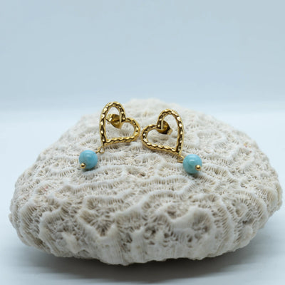Nouvelles boucles d'oreilles en forme de cœur, de couleur dorée, faite en acier inoxydable 316L. Chaque boucle à une perle de Larimar pendante à la base du cœur.
