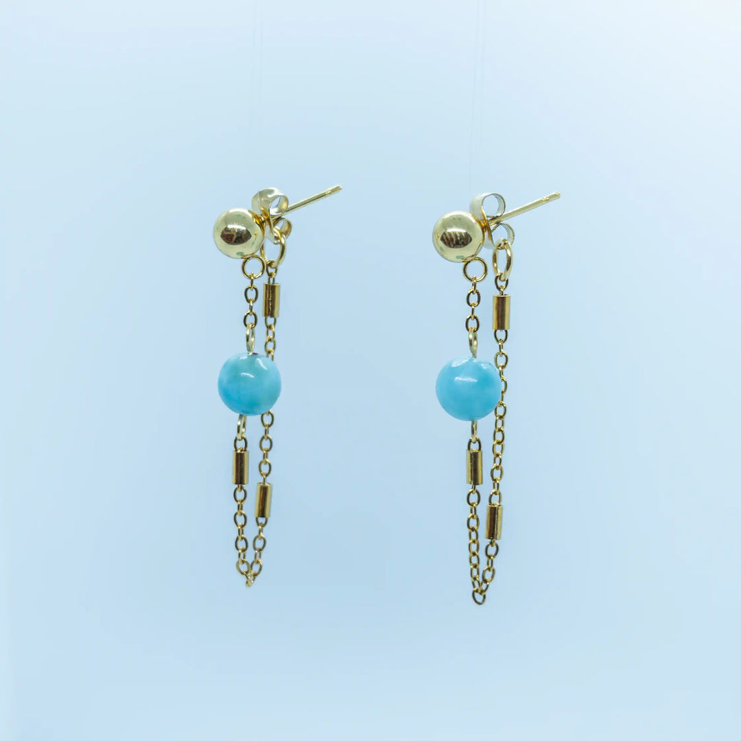 Paire de boucles d'oreille couleur dorée faite en acier inoxydable chirurgical, hypoallergénique, contenant chacune une chaînette faisant le lien entre une magnifique perle de Larimar, la boucle d'oreille et le fermoir.