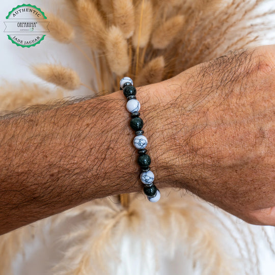 Bracelet avec des perles de Howlite blanche et de Jade Jaguar verte foncée séparées par des intercalaires en hématite noir. Bracelet en fil élastique fait main avec des perles de 8mm