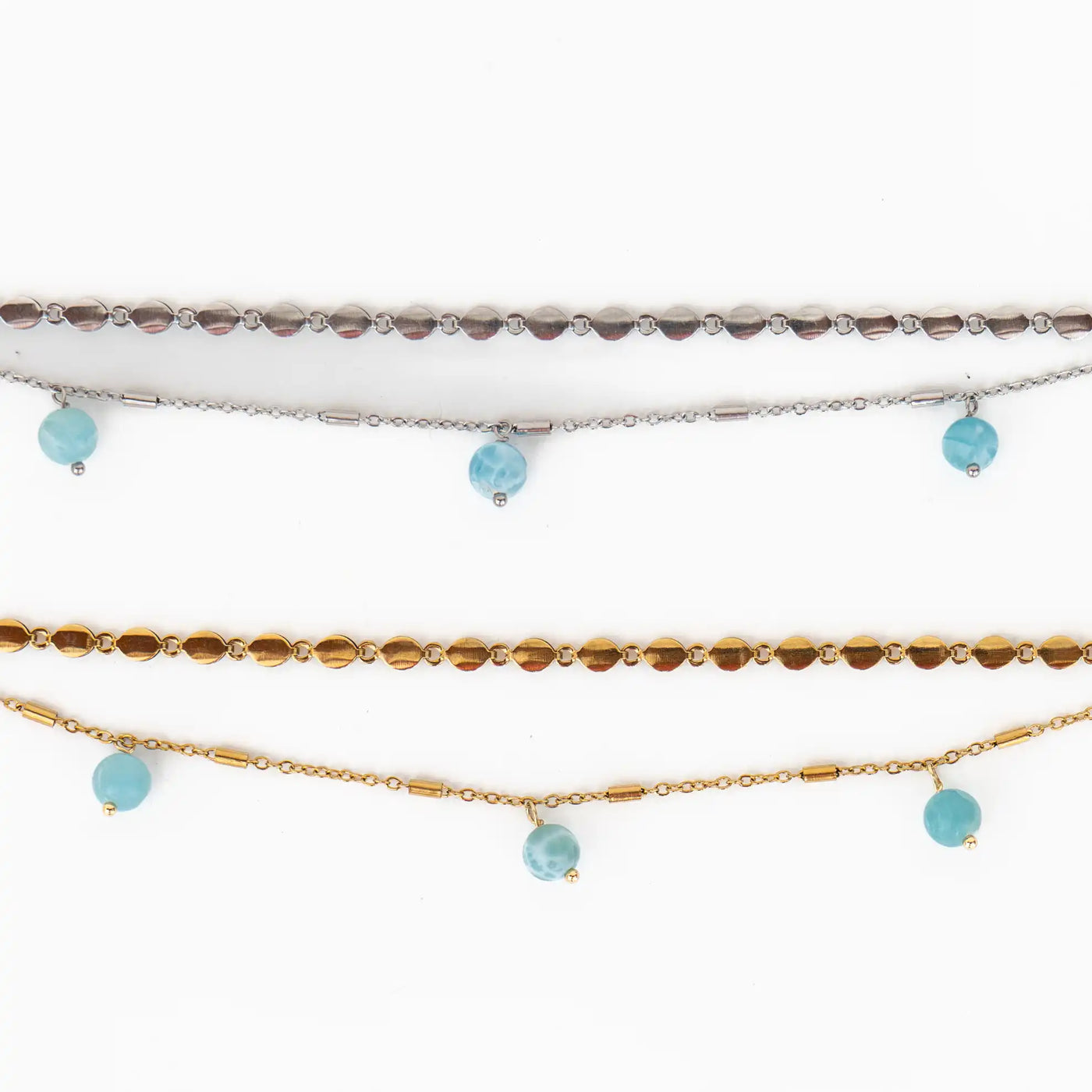 Photo de deux bracelets ouverts posés à plat sur fond blanc. Bracelets composés de deux chaîne différentes avec trois perles de larimar pendantes. Extension de chaîne avec une breloque orparima. Les chaînes sont en acier inoxydable 316L.