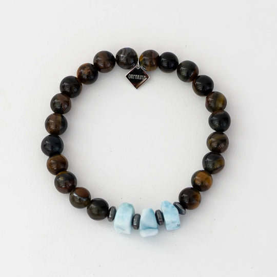 Bracelet personnalisable en oeil du tigre avec trois pierres larimar de forme carrés et une breloque orparima.