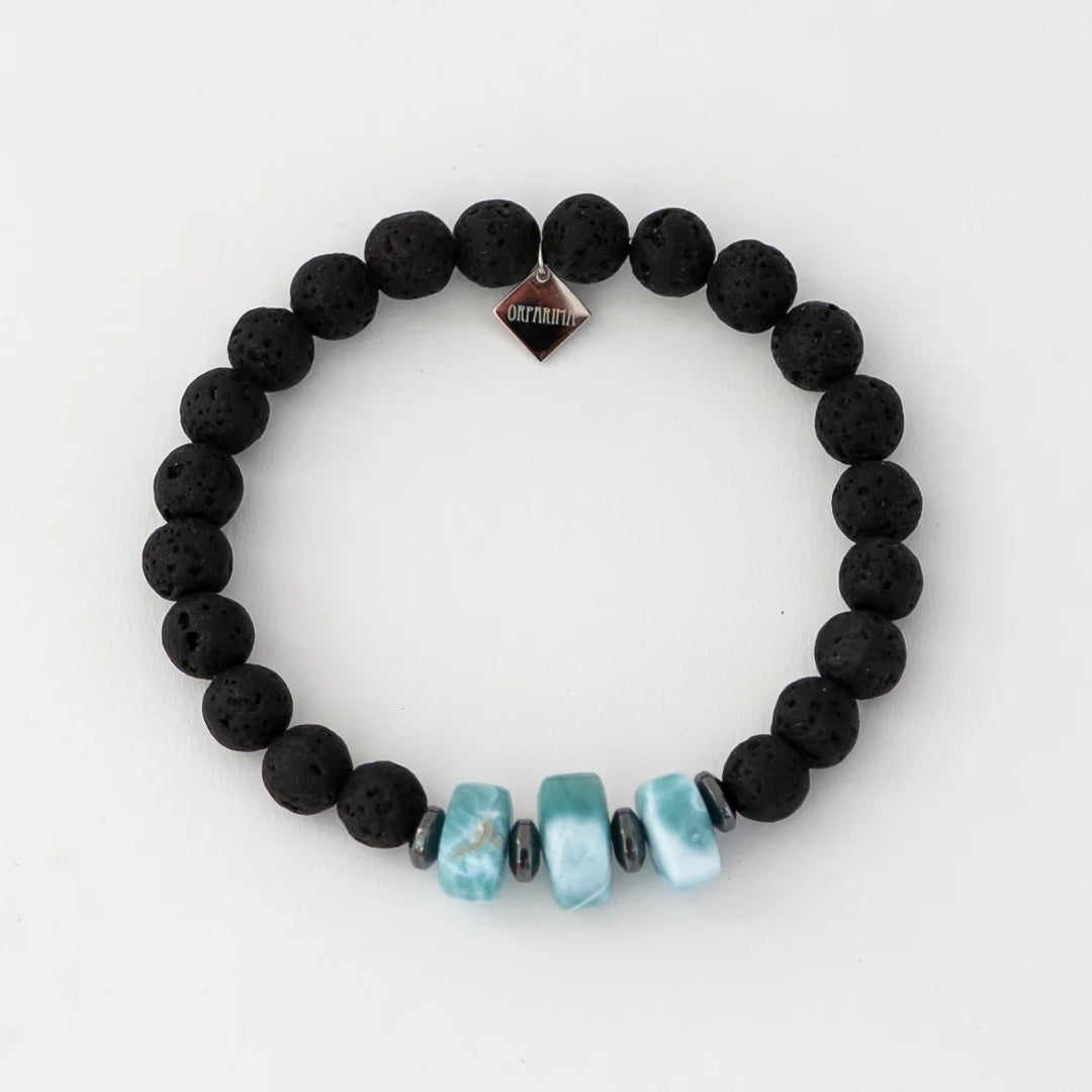 Bracelet noir en pierre de lave avec trois fragments de larimar de forme carrée. Bracelet avec une breloque orparima.