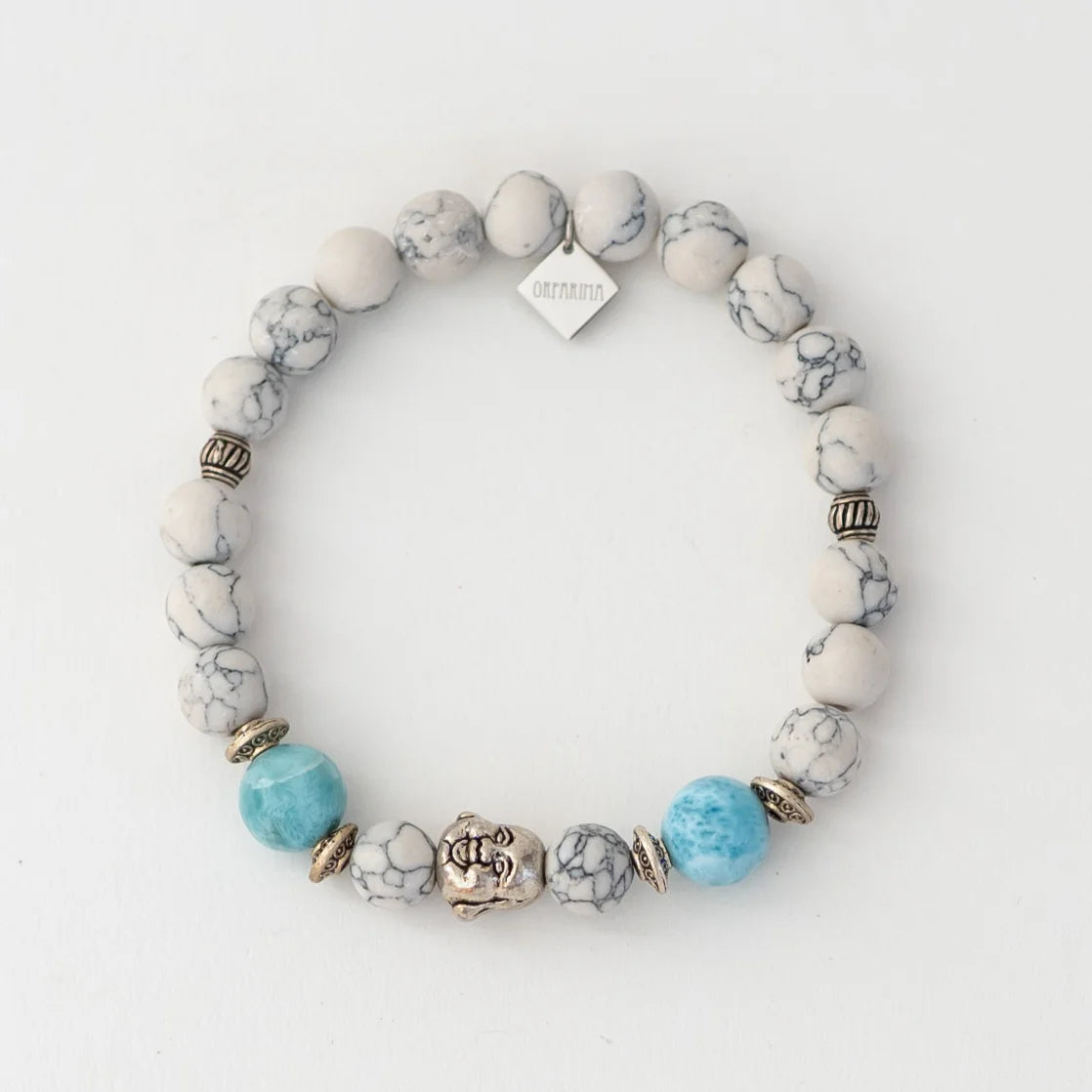 Bracelet en howlite blanche avec deux perles de larimar et une breloque bouddha.