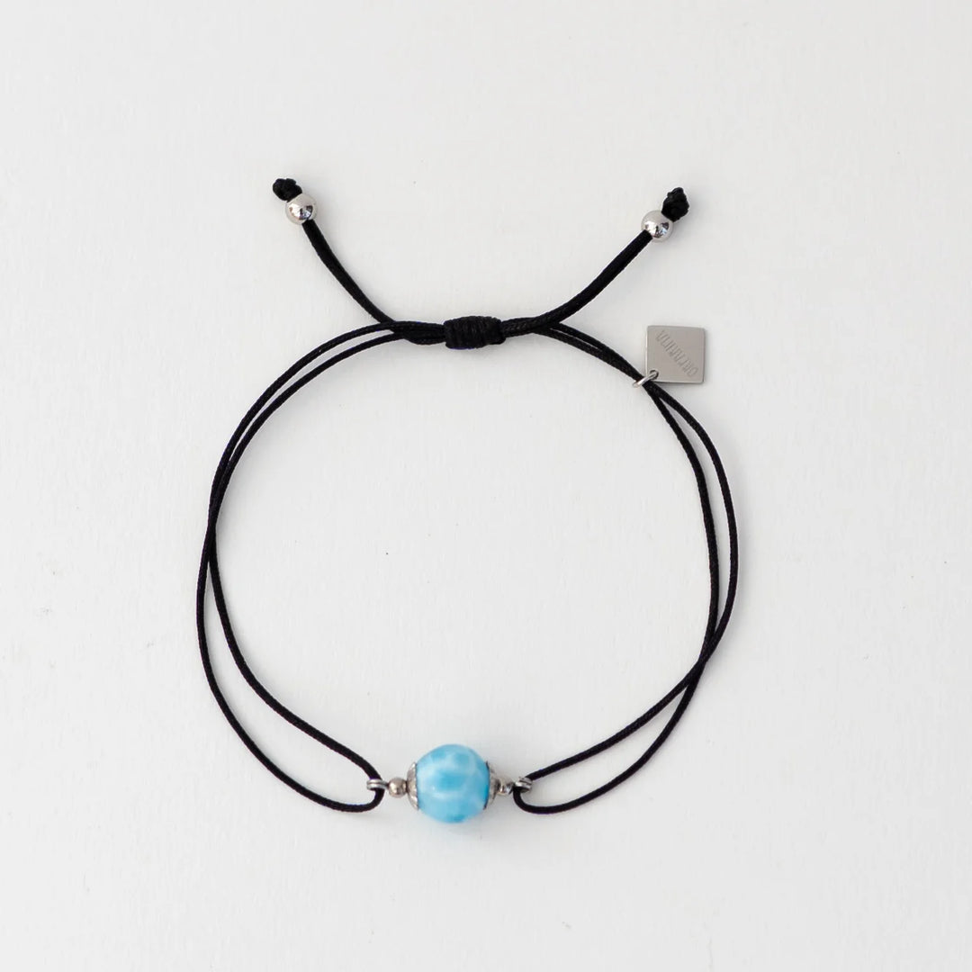 Bracelet en cordon noir avec une perle de larimar bleu faite à la main par notre artisan dominicain. Breloque orparima pendante. Resiste à l&