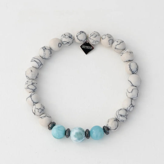Bracelet en howlite avec trois perles de larimar séparé par des intercalaires en hématite. Bracelet en fil élastique. 