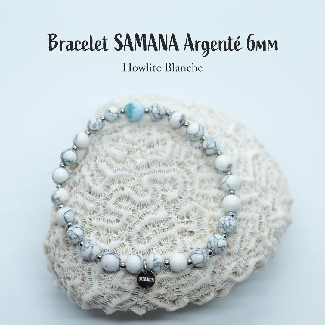 Bracelet en perles de 6mm en howlite blanche avec une perle de Larimar de République Dominicaine. Ce bracelet a une breloque en acier inoxydable 316L argenté avec une gravure orparima.