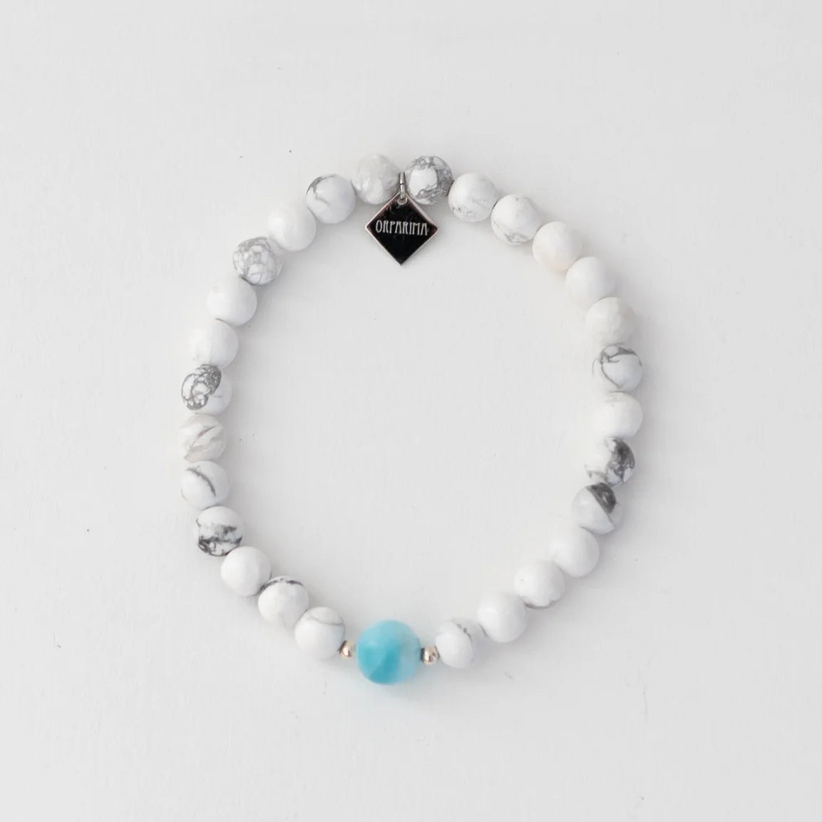 Bracelet en pierre ronde howlite de 6mm avec une pierre ronde de larimar de 6mm de diamètre. Breloque orparima sur le bas de bracelet