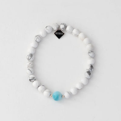 Bracelet en pierre ronde howlite de 6mm avec une pierre ronde de larimar de 6mm de diamètre. Breloque orparima sur le bas de bracelet