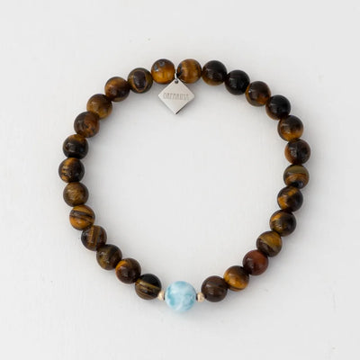 Photo d'un bracelet en pierre oeil du tigre de 6mm de diamètre et une perle de larimar bleue. Bracelet élastique résistant à l'eau fait sur mesure.