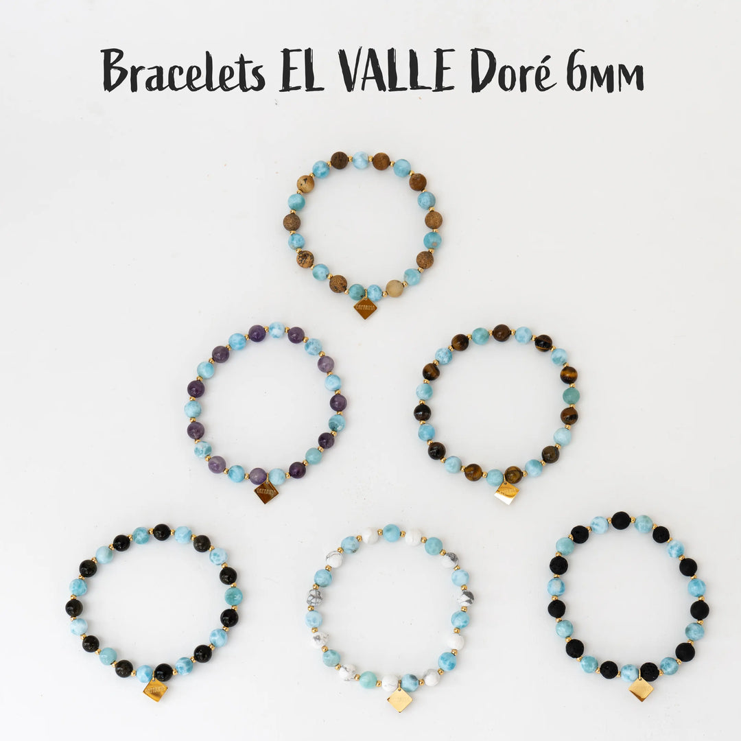 La collection complète avec 6 bracelets différents en perles de 6mm vues de dessus et posées sur fond blanc. Ces bracelets ont tous des perles de Larimar en association avec au choix de l'obsidienne, de la pierre de lave, de la jaspe paysage, de la howlite blanche, de l’œil du tigre ou de l'améthyste. Bijoux fait en fil élastique en République Dominicaine.