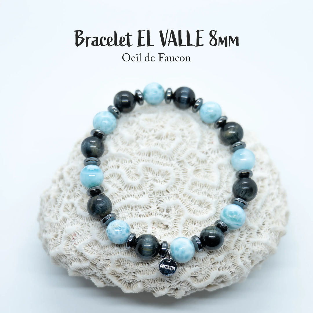 Bijou fait à la main en fil élastique avec une alternance de perles de Larimar et d’œil de faucon. Des intercalaires en Hématite séparent chaque perles.