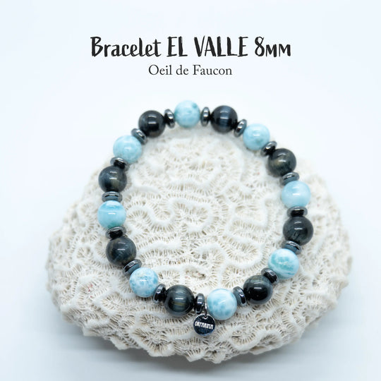 Bijou fait à la main en fil élastique avec une alternance de perles de Larimar et d’œil de faucon. Des intercalaires en Hématite séparent chaque perles.