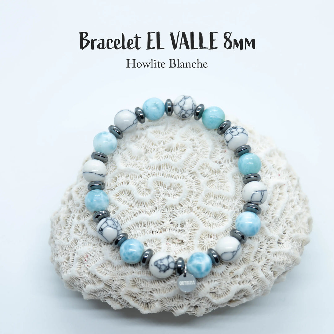 Bracelet en fil élastique avec une alternance de perles de Larimar et de perles de Howlite blanche. Chaque perle est séparée des autres par un intercalaire en hématite. Bijou fait en République Dominicaine.
