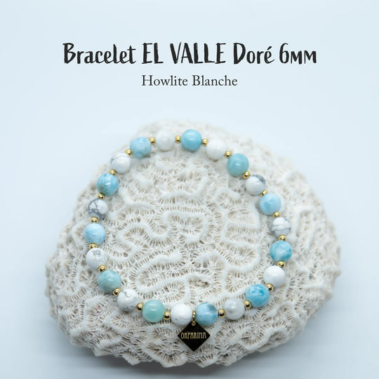 Une alternance de perles de 6mm de howlite et de perles de Larimar composent ce bracelet en fil élastique disponible en plusieurs tailles. Ce bijou est posé sur un coquillage blanc.