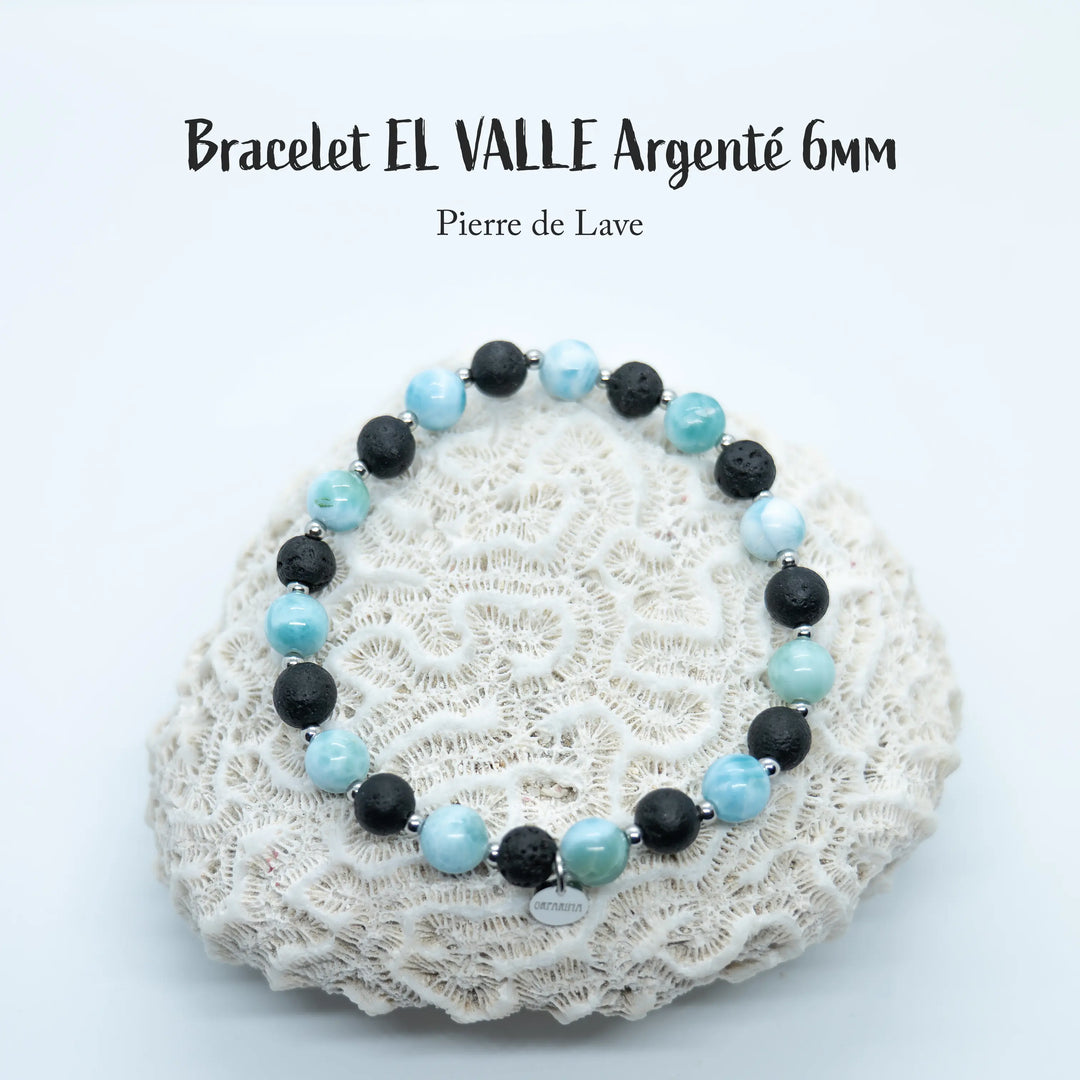 Bracelet posé sur un coquillage, fait avec un fil élastique, avec une alternance de perles de 6mm de pierre de lave et de Larimar. Bijou fait à la main en République Dominicaine et adaptable à plusieurs tailles de poignets.