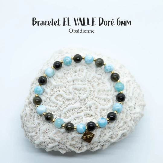 Bracelet posé sur un coquillage blanc, sur fond blanc, composé d&