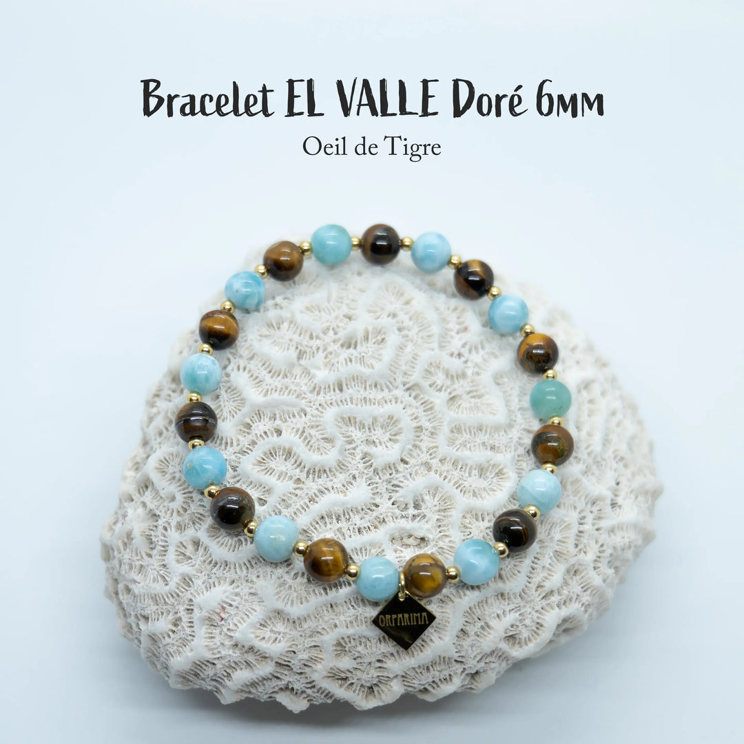 Bracelet en œil du tigre et en Larimar avec des perles de 6mm de diamètre, monté avec un fil élastique avec des petites perles en acier inoxydable 316L doré séparant chaque perles du bracelet.