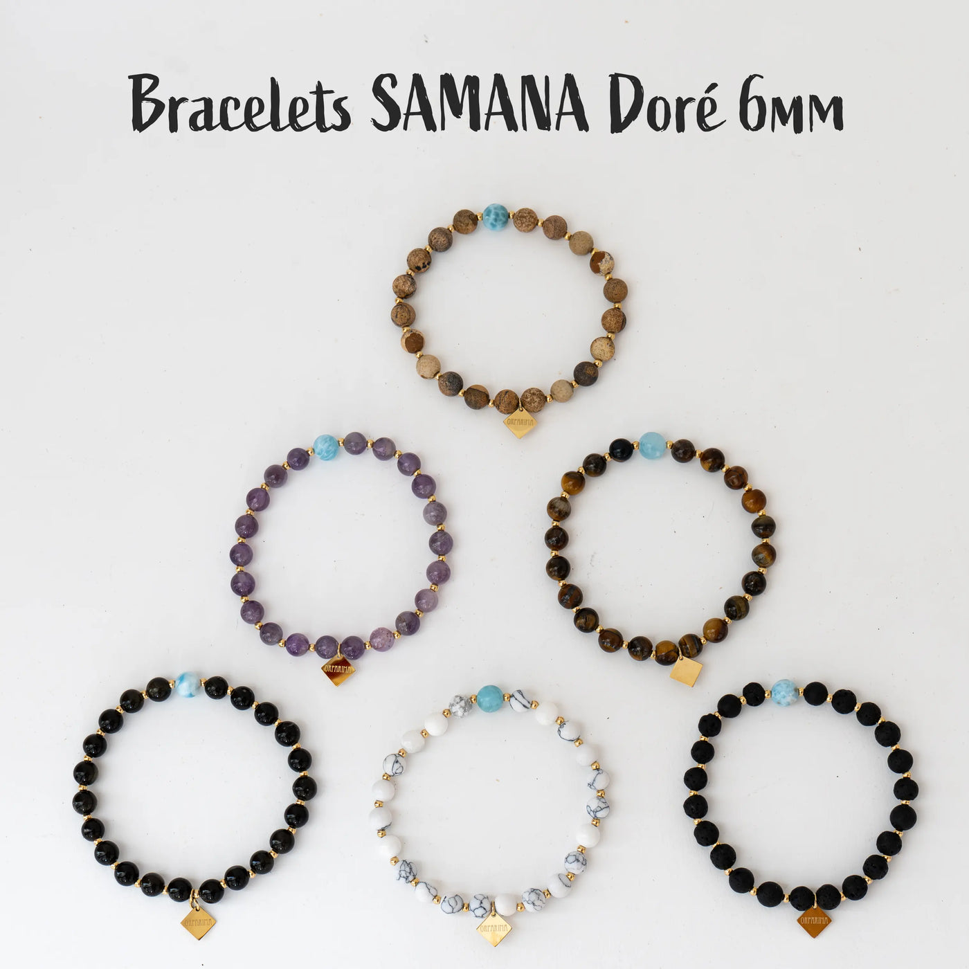 Photo de six bracelets avec des perles de 6mm de diamètres, vue de dessus. Chaque bracelet est fait en pierre naturelle différente comme la jaspe paysage, l'obsidienne, l’œil du tigre, l'améthyste, la pierre de lave ou la howlite. Chaque bracelet à une pierre de Larimar de 7mm de diamètre de couleur bleue et une breloque en acier inoxydable de couleur doré.