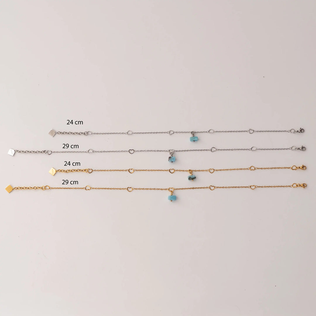 Quatre modèles de chaînes de chevilles de 24cm et 29cm de couleur argent ou doré avec sur chacune un fragment de larimar bleu en pendant. Chaque modèle possède une chaîne d&