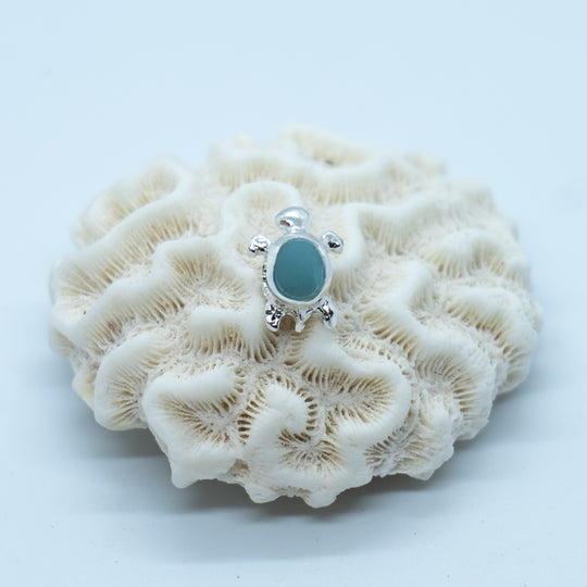 Petit charme en argent 925 en forme de tortue avec une pierre de Larimar en son centre.