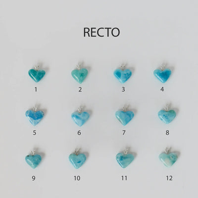 Pendentif en Larimar taillé en forme de cœur avec sa bélière en argent 25. Un total de douze cœurs sont disposés sur leur face recto sur un fond blanc.