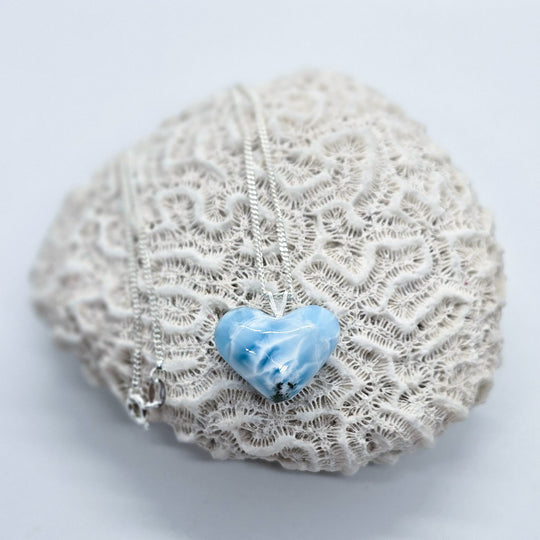 Cœur en Larimar de République Dominicaine monté sur une chaîne en argent 925. Ce cœur unique aux différentes nuances de bleu possède quelques résidus de roche sur sa partie basse.