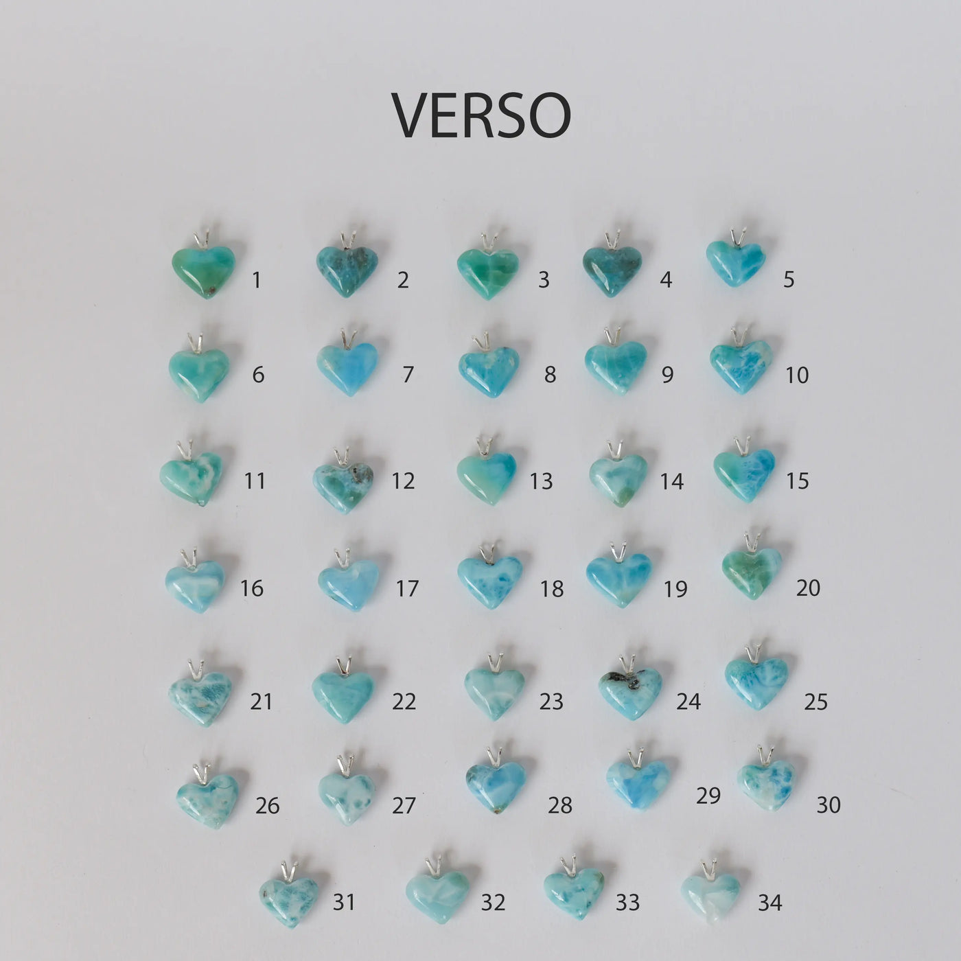 Vue de la face verso de trente-quatre cœurs en Larimar de République Dominicaine avec chacun sa bélière en argent 925. Chaque cœur est unique et peut être monté sur un fil transparent ou une chaine en argent 925.