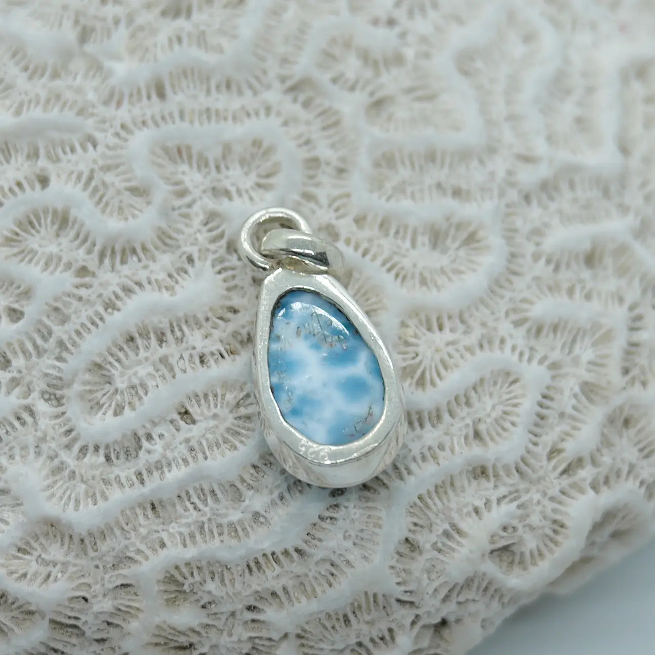 Cabochon en Larimar serti en argent 25 avec la face verso ouverte pour avoir la pierre naturelle au contact de la peau.