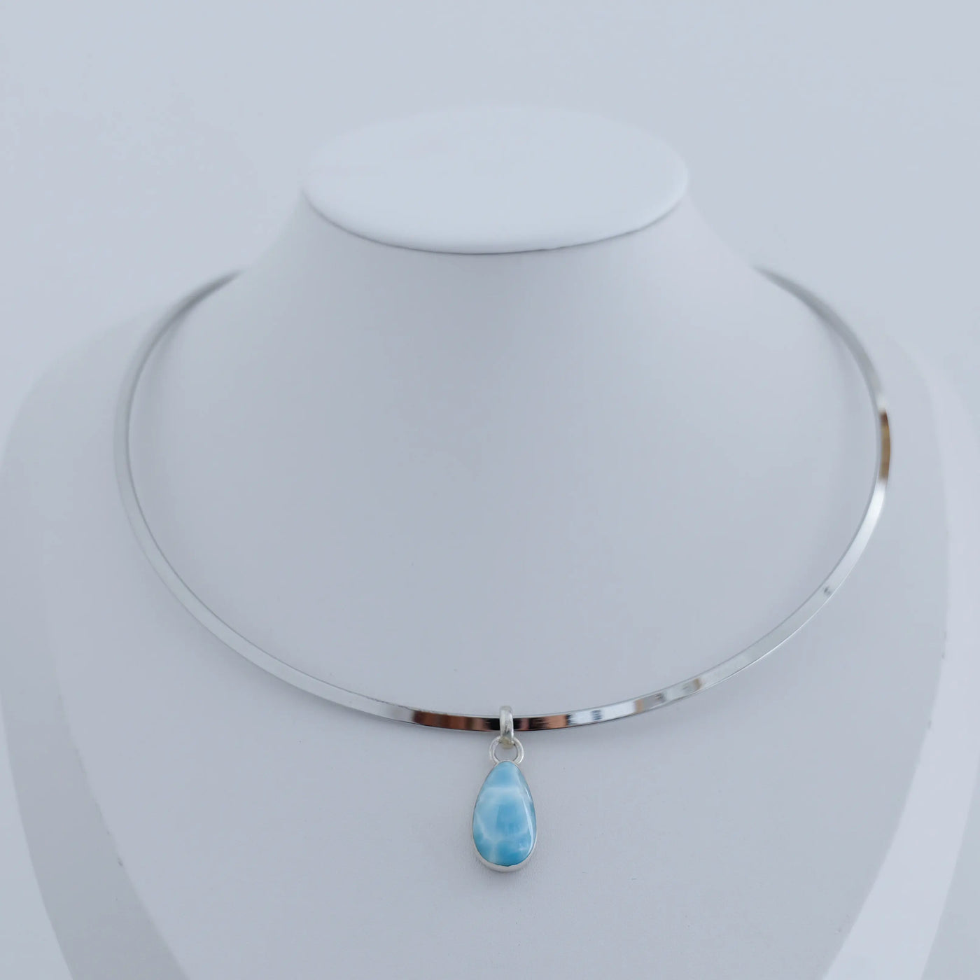 Collier rigide en acier inoxydable 316L avec un pendentif en argent 925 et son cabochon en Larimar taillé artisanalement.