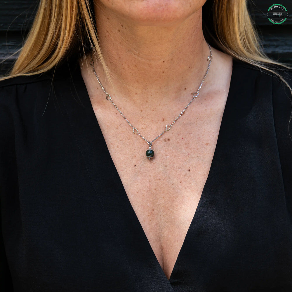 Perle de Jade Jaguar Maya verte foncé venant du Guatemala montée sur un collier en acier inoxydable 316L de couleur argenté. Bijou artisanal fabriqué en République Dominicaine