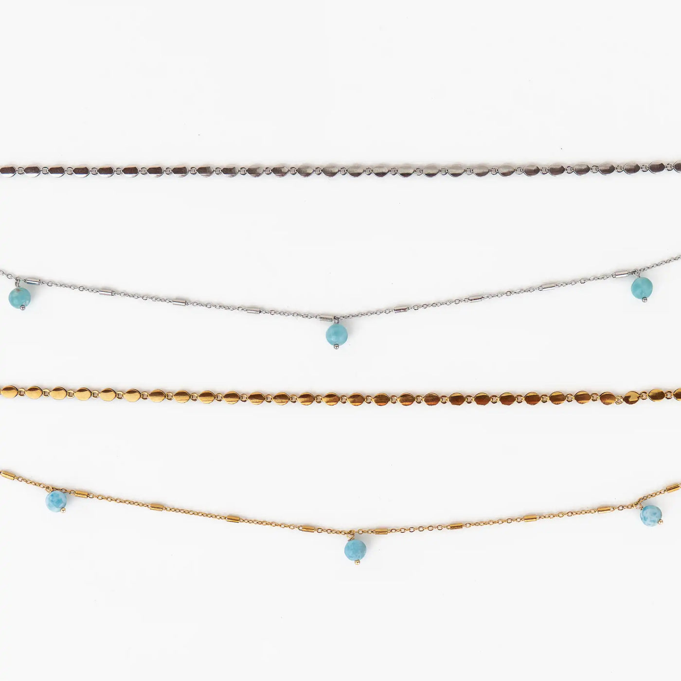 vue proche de deux colliers composés de deux chaînes différentes, l'une est épaisse et l'autre fine. Trois perles de larimar sont réparties sur la chaîne du bas de chaque collier. Bijou en acier inoxydable 316L argenté ou doré.