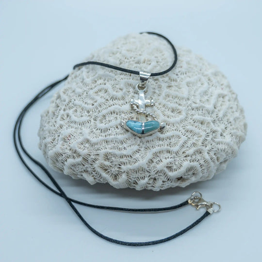 Bijou fait à la main représentant une ancre de bateau avec une pierre de Larimar bleue. Le collier est un fil noir et le pendentif est fait en argent 925.
