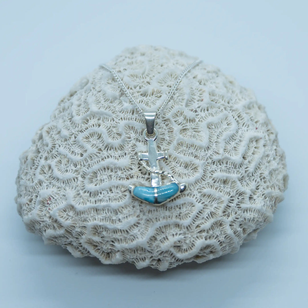 Bijou en argent 925 avec sa chaîne et son pendentif en forme d'ancre de bateau composé de deux pierres de Larimar. Bijou fabriqué à la main en République Dominicaine.