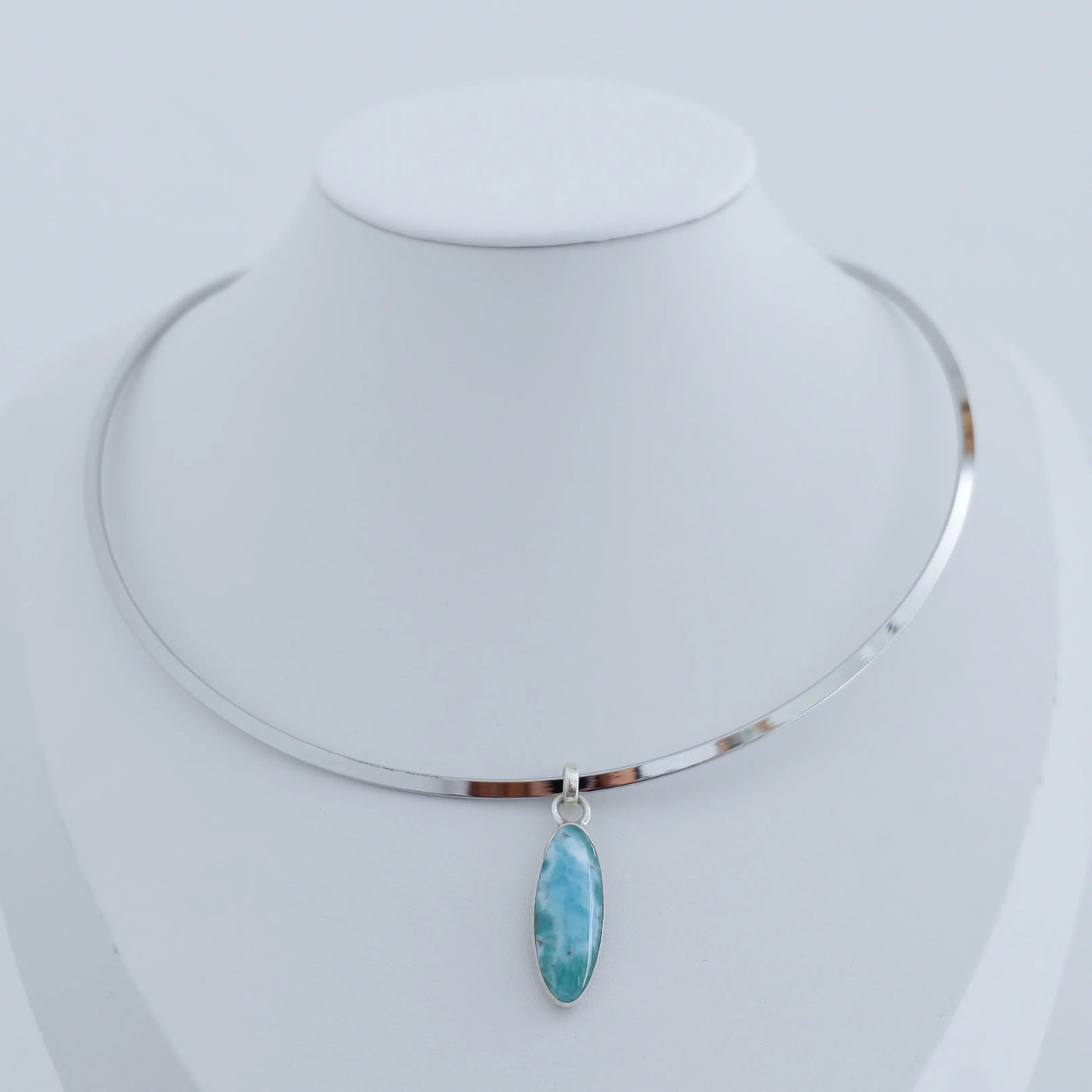 Collier d'exception monté sur un tour de cou rigide en acier inoxydable et son pendentif de couleur bleu en Larimar dominicain.