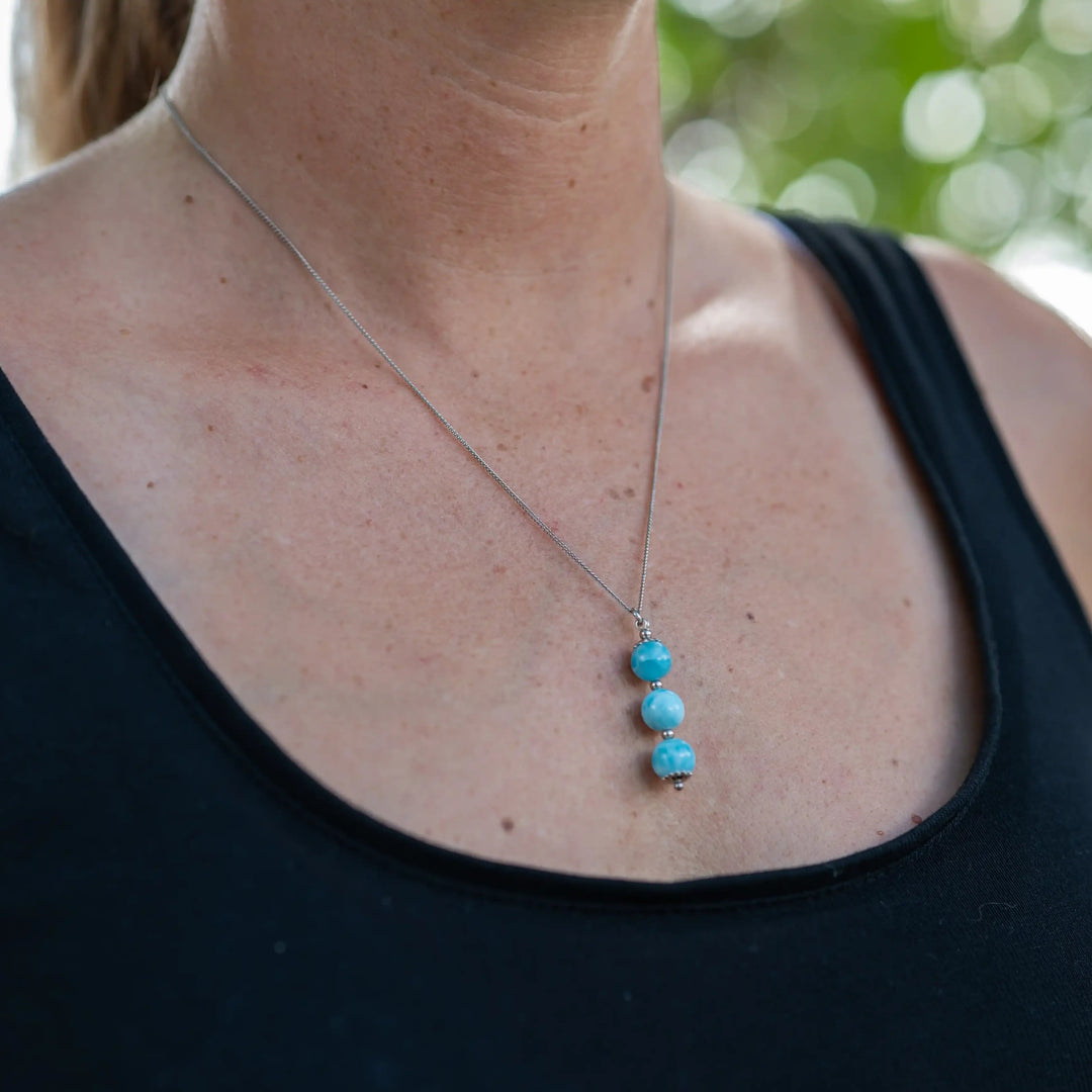 Collier argenté en acier inoxydable 316L et son placage PVD coating résistant à la corrosion. Collier avec trois perles de larimar bleu pendante le long d&