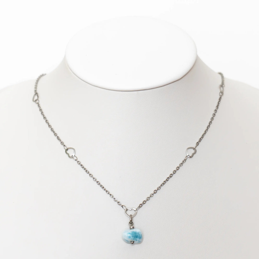 Collier raz le cou avec un pendentif en pierre de Larimar. Bijou fait en acier inoxydable de couleur argentée. Le pendentif en Larimar est de couleur bleue. Bijou fait à la main.