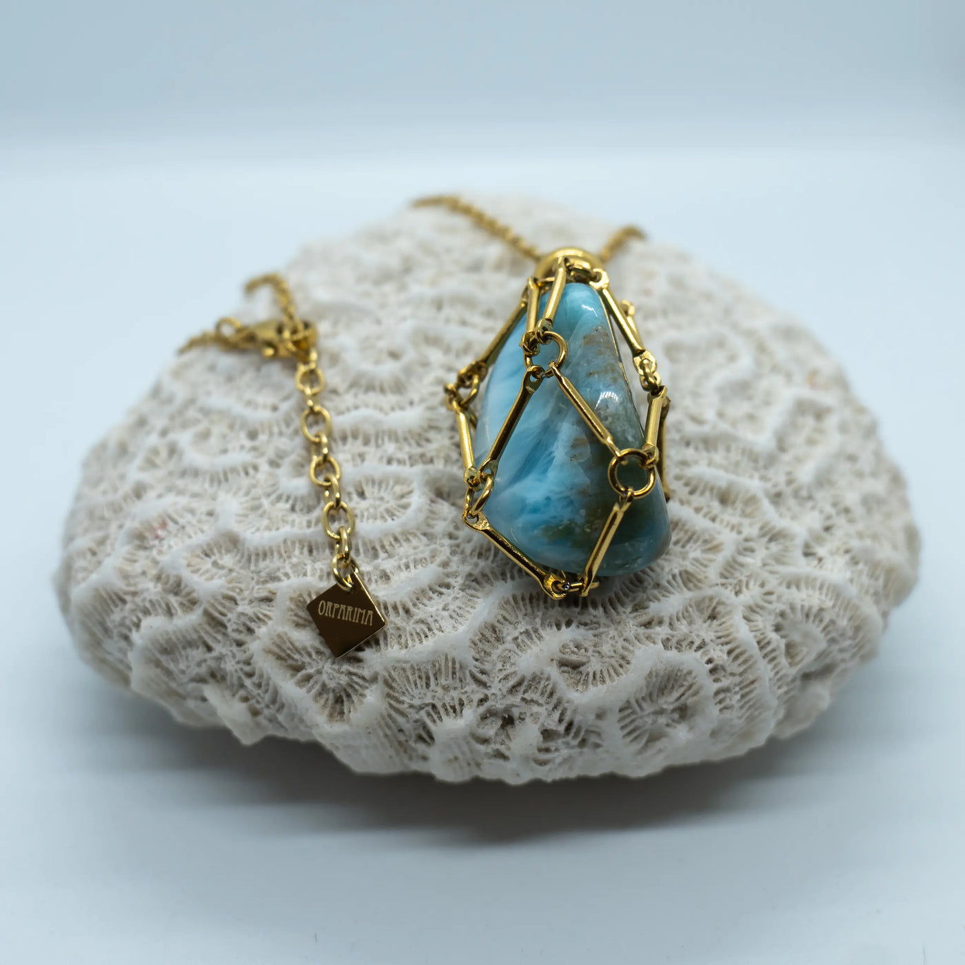 Pierre de Larimar polie dans une cage en acier inoxydable. Bijou collier en acier inoxydable de couleur doré.