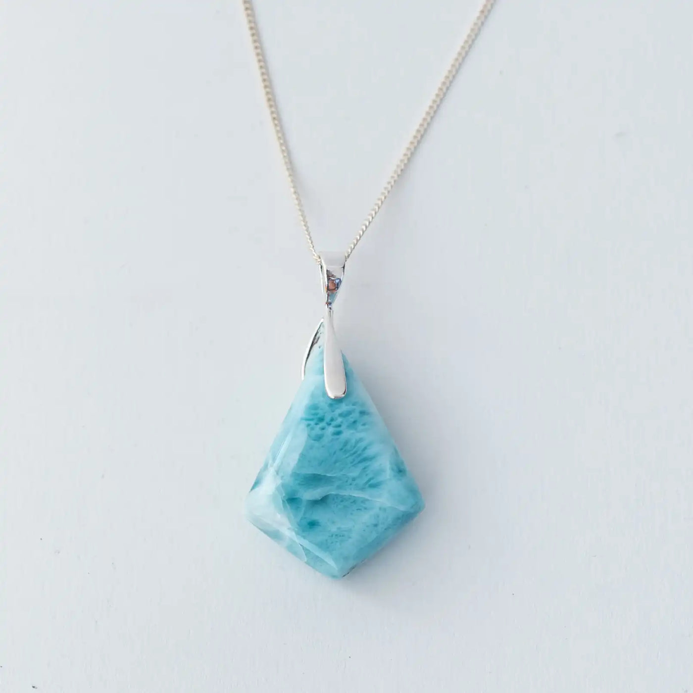 cabochon en forme de losange taillé dans la pierre de larimar de République Dominicaine, de couleur bleu intense, monté sur une chaîne en argent.