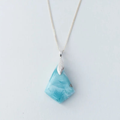 Face recto d'un collier en larimar en forme de losange monté sur une chaîne en argent 925. Pierre naturelle de République Dominicaine de couleur bleu avec différentes teintes de bleu.